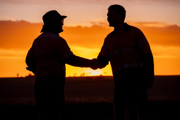 Crisis Communications Farmers shaking hands at sundown