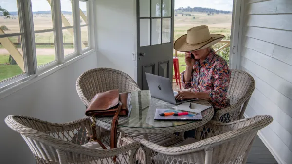 Crisis comms social media lady sitting at table working on a laptop