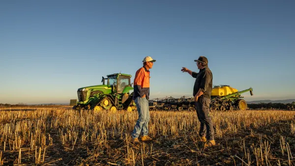 Crisis comms module 2 2 men standing in paddock in front of farm machinery